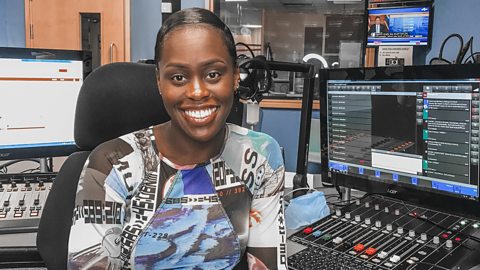 Aminata is sitting at her desk in her 鶹Լ studio