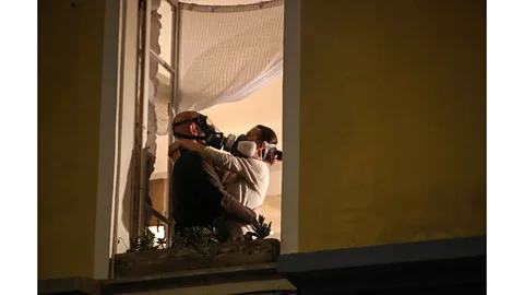 Valery Hache/AFP via Getty Images A couple wearing masks embrace during a daily round of applause for health workers in Nice, March 2020 (Credit: Valery Hache/AFP via Getty Images)