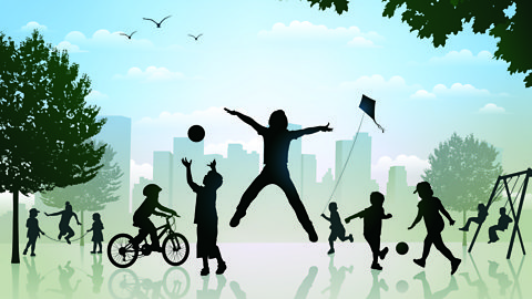 Silhouettes of children playing in a city park - riding a bike, jumping, on the swings, kicking a ball, flying a kite and skipping.