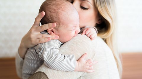 A mum holding her crying baby.