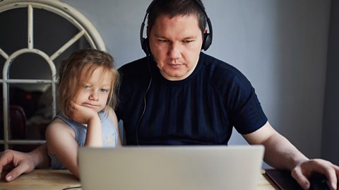 Bored daughter watches Dad on laptop