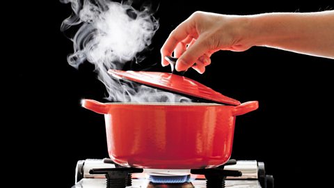 Woman putting a lid on a pan