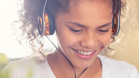 Girl with headphones on smiling.