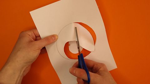 Scissors cutting a shape out by cutting the hole in sections