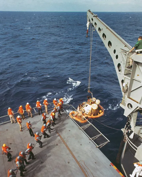 Getty Images A crane lifts the Apollo 11 capsule onto the ship, but the astronauts were already onboard (Credit: Getty Images)