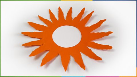 A 2D sun made from paper with a hole in the middle