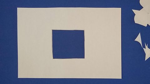 A piece of paper with a square hole cut out of it