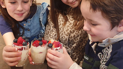 A little boy and his 2 sisters with overnight oat pots.