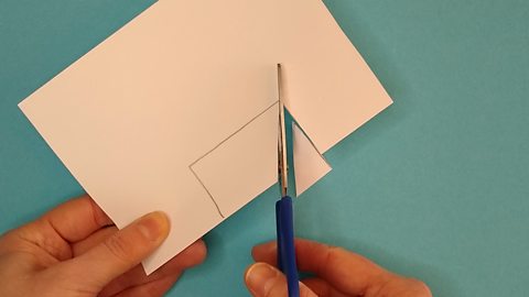 Scissors cut into a square shape cut on a folded piece of paper