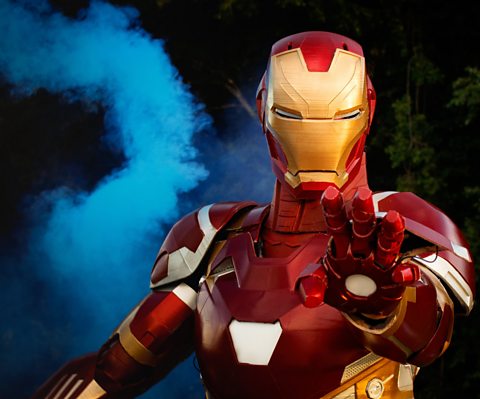 Emily Yarid wearing a red and gold 3D printed Iron Man suit with a blue flare in the background.