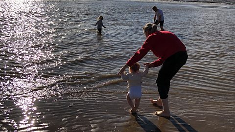 Molly on the beach with her two children and her husband.