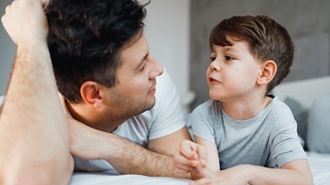 Young boy talks as his father listens keenly