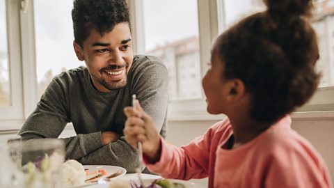 Father and daughter talk to each other at lunchtime