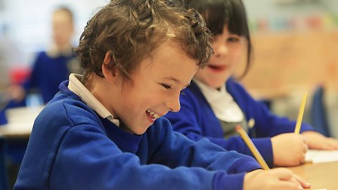 Young boy and girl laugh together at school