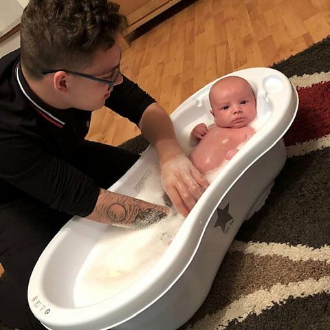 Lewis bathing his son when he was very young.