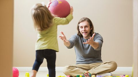 A dad and daughter playing a game of catch