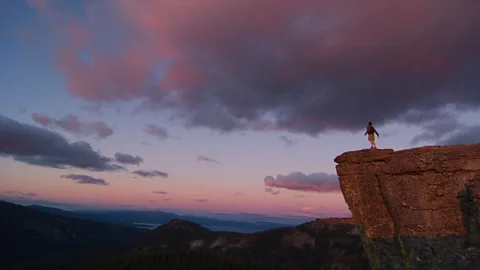 Alamy File image of a man on a cliff at sunset
