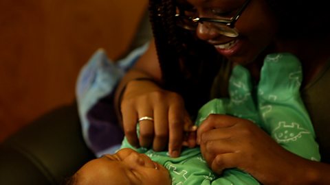 A mum chatting with her baby son face to face.