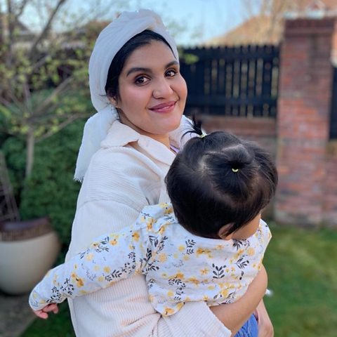 Mother with young baby held in her arms.