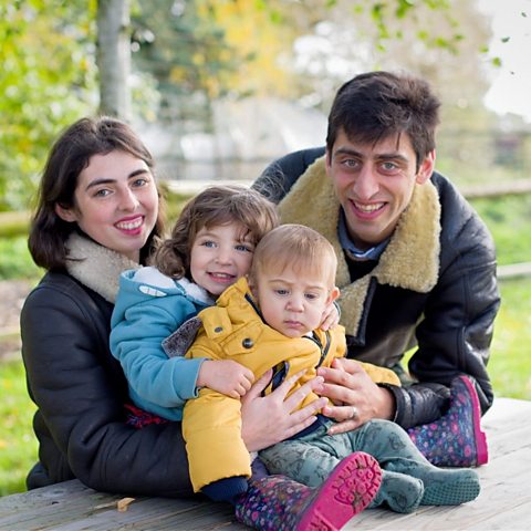 Young family with their children seated at a picnic bench