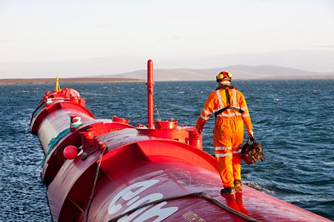 A Pelamis P2 wave energy generator on the dockside at Lyness on Hoy, Orkney Isles, Scotland