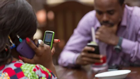 Alamy A couple, on their phones, in Lagos, Nigeria