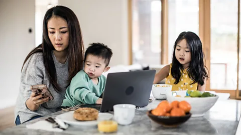 Getty Images woman trying to work while caring for children