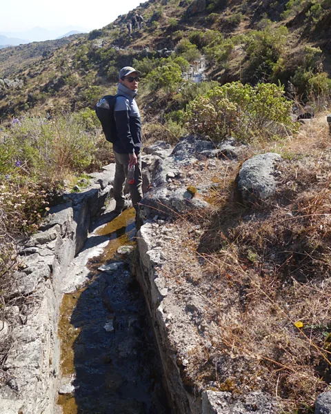 Erica Gies Researcher Boris Ochoa-Tocachi stands in a mortared portion of an amuna, now running low on water, having delivered its flow to the infiltration basins (Credit: Erica Gies)