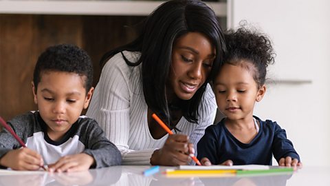 A mum drawing with her son and daughter.