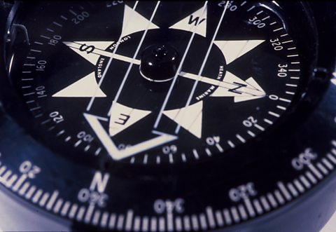 A close up photograph of a black and white compass.