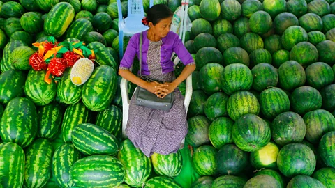Gettty Images Woman sitting surrounded by watermelons (Credit: Gettty Images)