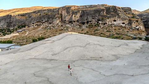 Bulent Kilic/Getty Images Children play on a concrete plain created to protect a mosque in Hasankeyf, Turkey from the deliberate flooding of a reservoir (Credit: Bulent Kilic/Getty Images)