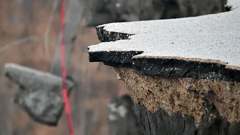 Josh Edelson/Getty Images It may be strong, but all things erode eventually. Chunks of concrete and asphalt hang over a cliff in Pacifica, California after a storm (Credit: Josh Edelson/Getty Images)