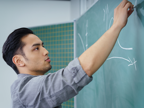 A person draws on a blackboard