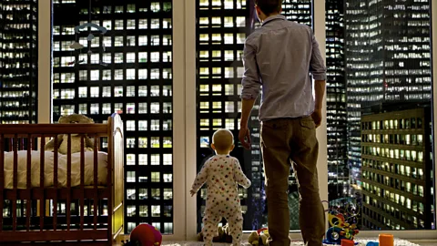 Getty Dad with two little kids crossing a city street