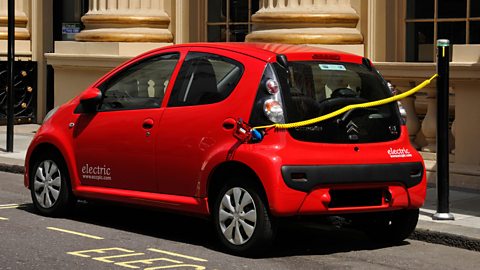 An electric car being charged on a street