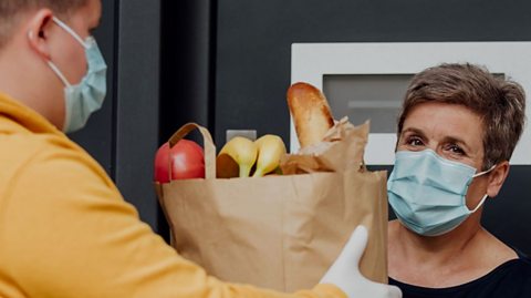 Woman receiving grocery delivery in pandemic