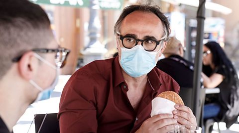 Two people eating outside a restaurant during the pandemic