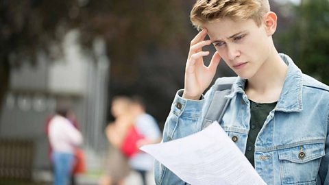 A student looking worried reading their exam results.