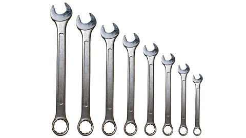 A set of metal spanners of different lengths and increasing in size.