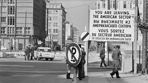 A sign on the border of east and west Berlin, which reads 'You are leaving the American sector'. 