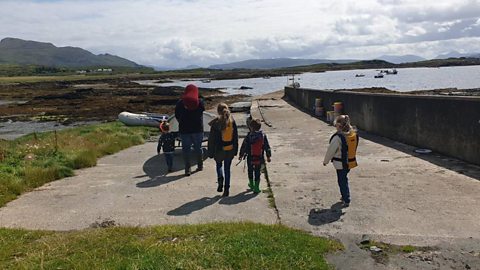 Ranger Hamza and his godchildren taking some kayaks down to the waterfront.