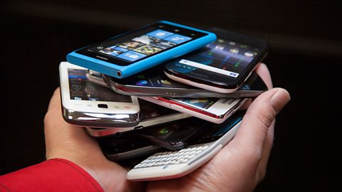 A pile of phones in a person's hands