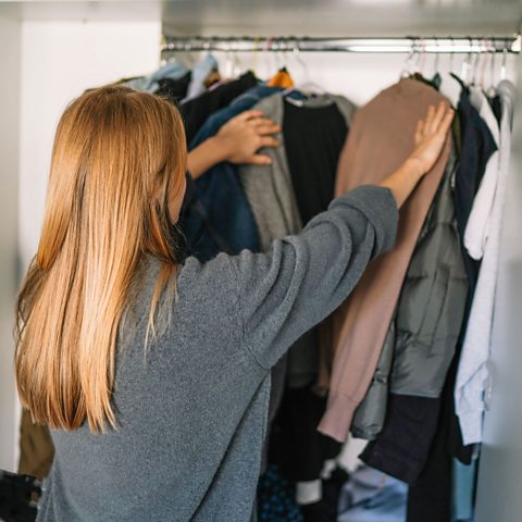 Woman organising clothes in wardrobe