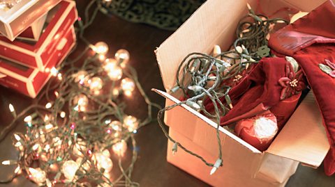 Christmas lights and other decorations in a box and on the floor