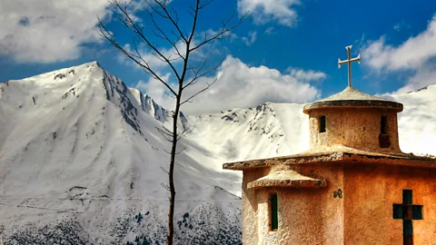 Konstantinos Lagos/Getty Images Church and snowy mountain view at Agrafa, Greece