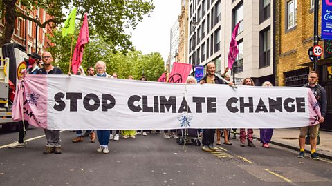 Demonstrators holding a 'Stop Climate Change' banner during a protest in London.