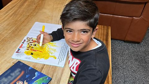 Six year old Paras colouring in and reading a book