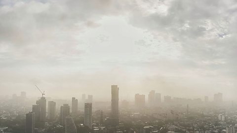 Cityscape and skyline that is filled with smog and polluted air reducing its visibility.