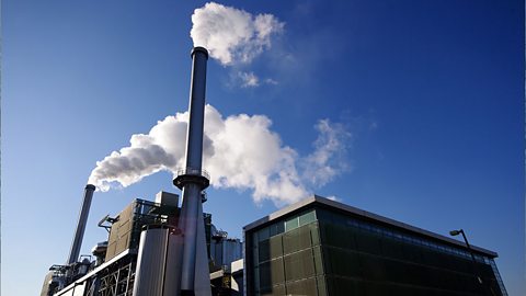 Waste incinerator during the day with smoke coming out of two chimneys